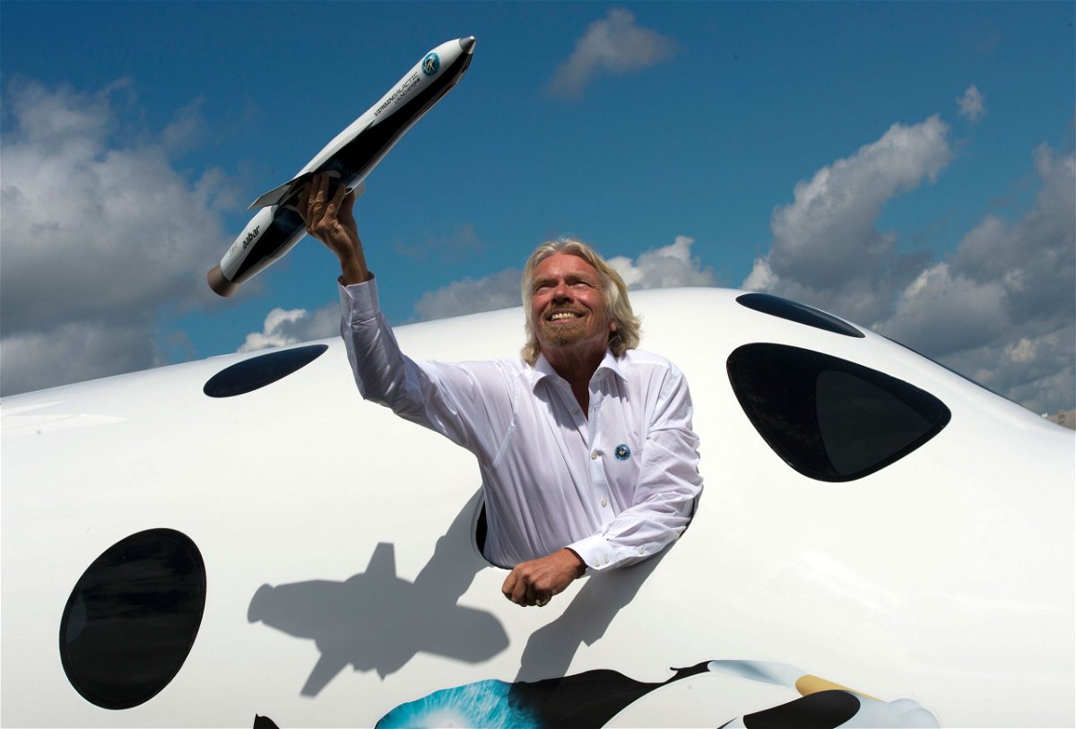 <i>Adrian Dennis/AFP/Getty Images</i><br/>Richard Branson is attempting to become the first billionaire to travel to space. Branson poses for photographs in the window of a replica of the Virgin Galactic in Hampshire