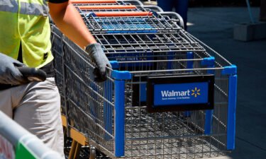 An employee gathers shopping carts at Walmart