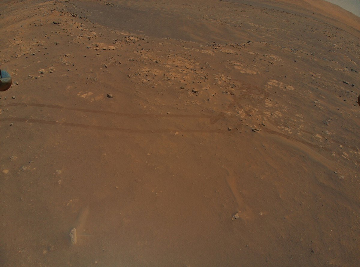 <i>JPL-Caltech/NASA</i><br/>The Ingenuity helicopter is flying in parallel with the Perseverance rover as it drives on Mars -- as shown by the rover tracks captured by the chopper's camera on July 5.