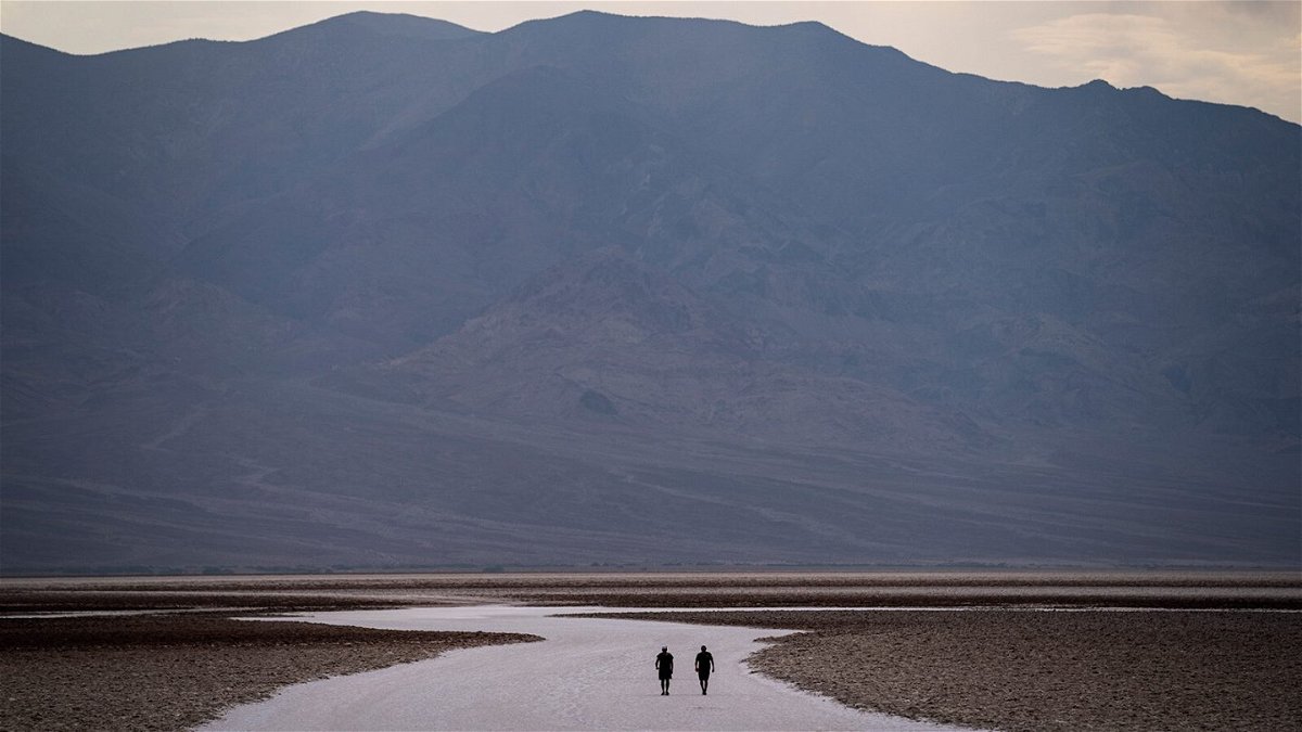 <i>John Locher/AP</i><br/>People walk on salt flats in Badwater Basin in Death Valley National Park