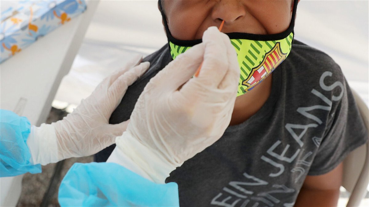 <i>Mario Tama/Getty Images</i><br/>A boy receives a free Covid-19 test at a St. John's Well Child & Family Center mobile clinic set up outside Walker Temple AME Church in South Los Angeles amid the coronavirus pandemic on July 15