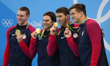 Members of the U.S. men's 4x100 medley relay team hold up their gold medals