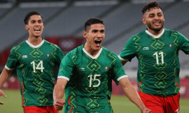 Mexico forward Uriel Antuna (center) celebrates with forward Alexis Vega (right) and midfielder Erick Aguirre after scoring the third goal during the Tokyo 2020 Olympic Games men's group A first round football match between Mexico and France at Tokyo Stadium.