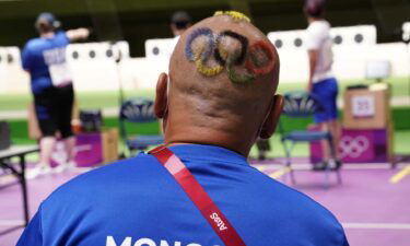 Mongolian shooting coach with hair cut into Olympic rings