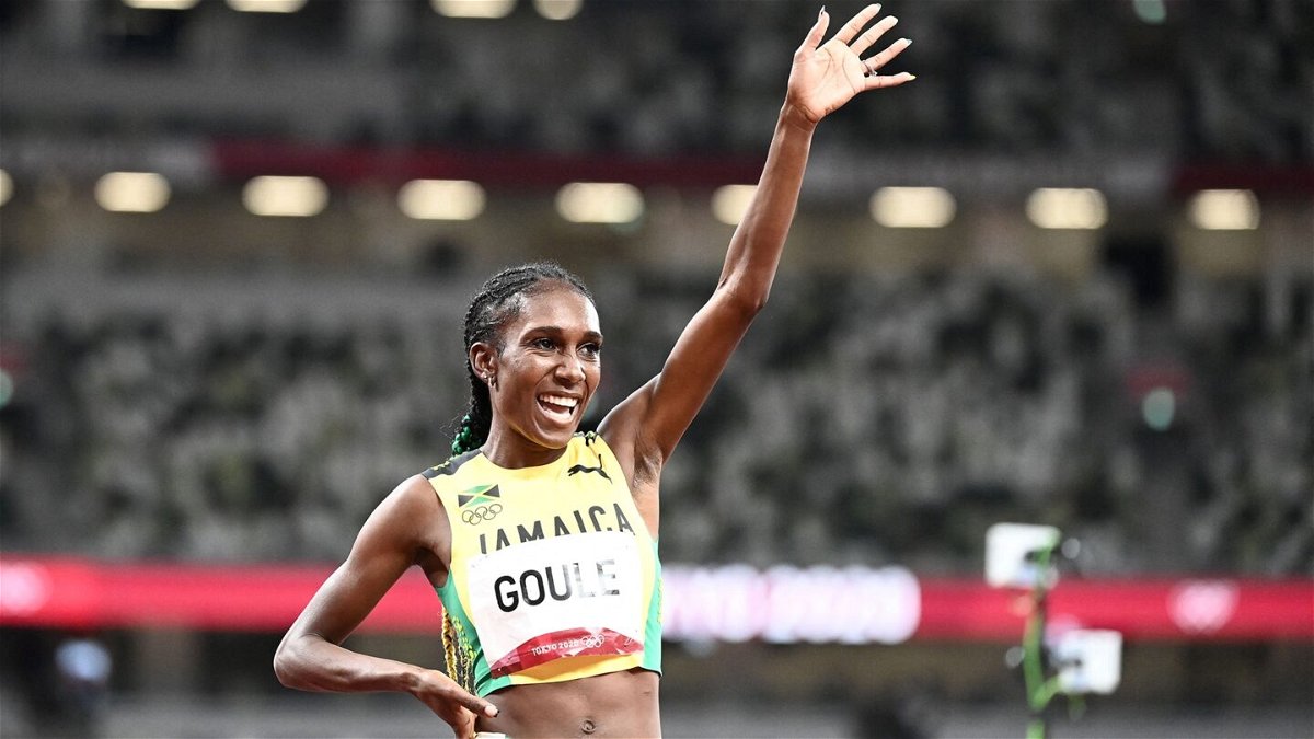 Jamaican runner Natoya Goule raises an arm after running the fastest time in the heat