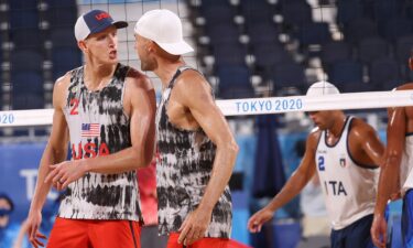 Jacob Gibb and Tri Bourne address each other during a beach volleyball match