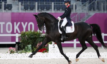 A horse and rider ride in an arena