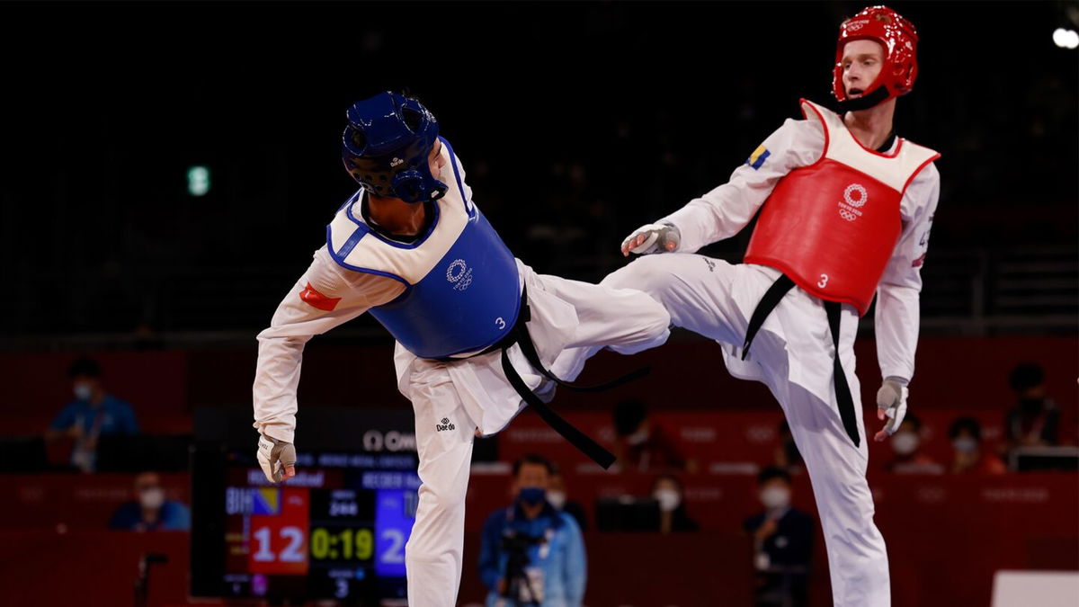 Hakan Recber and Nedzad Husic raise their legs in taekwondo competition