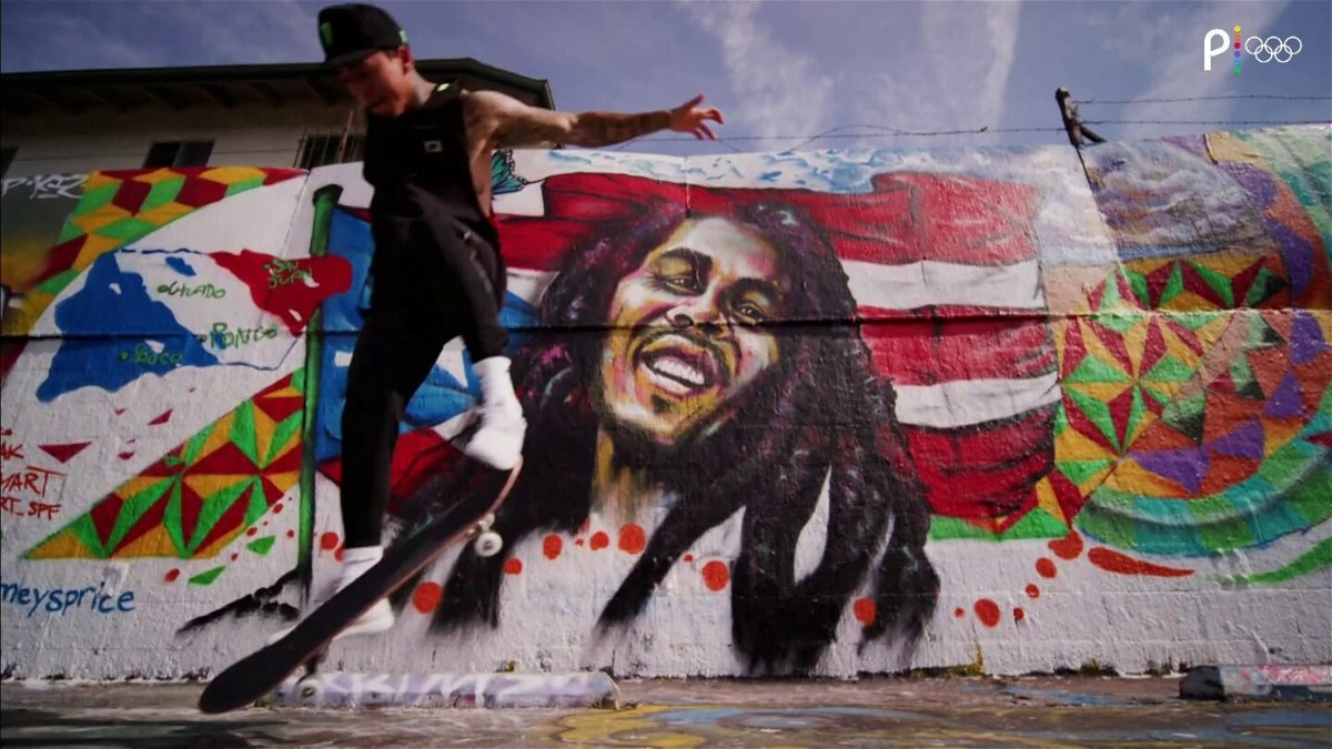 Nyjah Huston skateboards in front of a painted wall