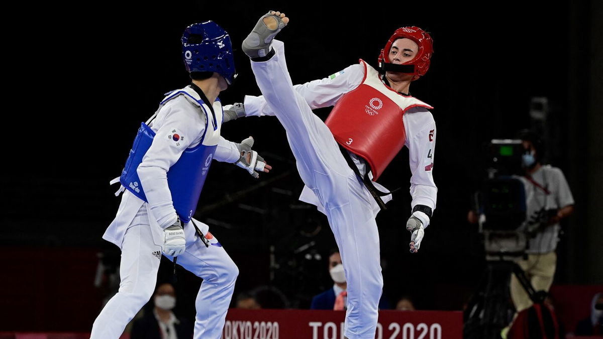 South Korea's Lee Daehoon (Blue) and Uzbekistan's Ulugbek Rashitov (Red) compete in the taekwondo men's -68kg elimination round bout during the Tokyo 2020 Olympic Games at the Makuhari Messe Hall in Tokyo on July 25