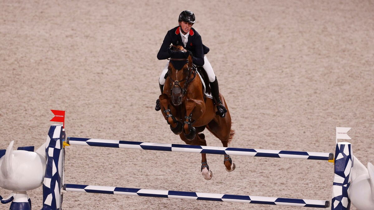 Ben Maher and his horse jump a blue and white jump