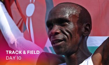 Eliud Kipchoge of Kenya winner of the gold medal crosses the finishing line and celebrates with a flag during the NN Mission Marathon