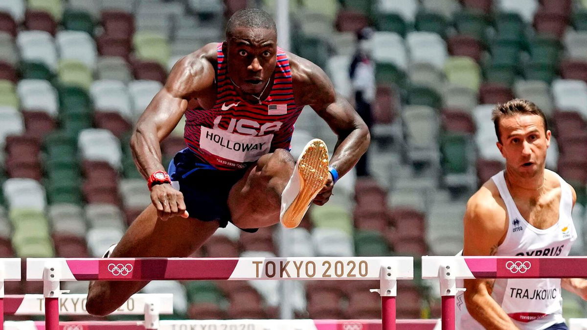 Grant Holloway jumps a hurdle on the track