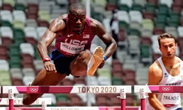 Grant Holloway jumps a hurdle on the track