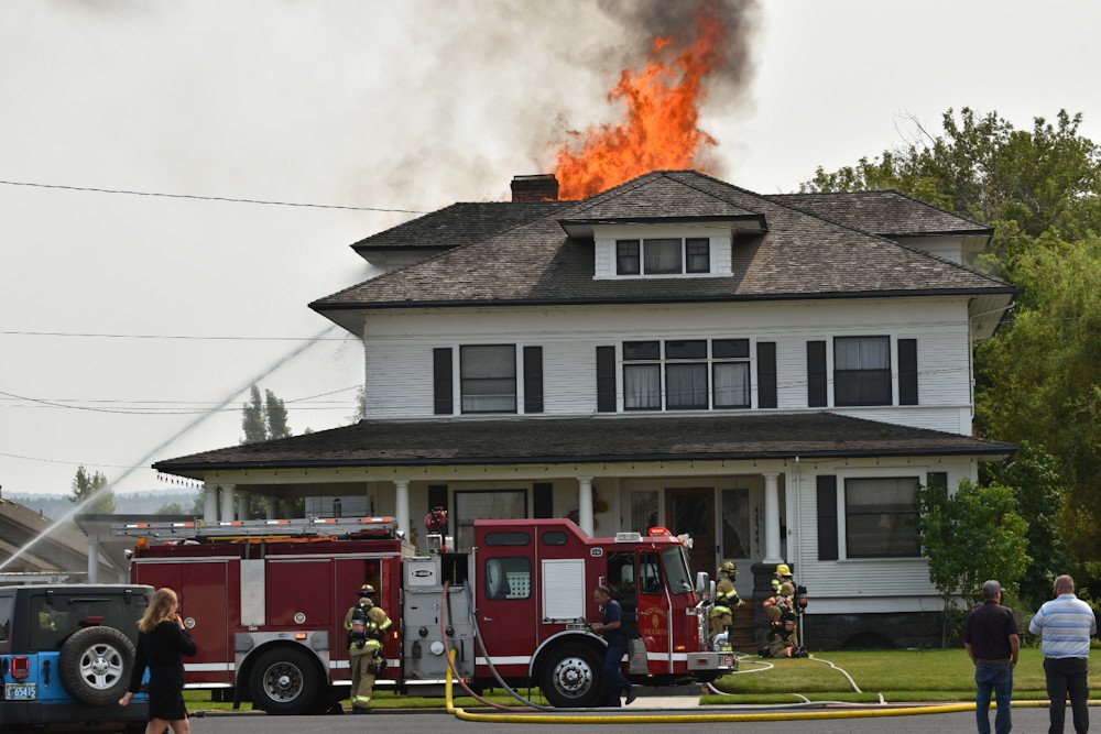 Flames rise from the roof of the historic Thomas Baldwin House in Prineville Thursday afternoon