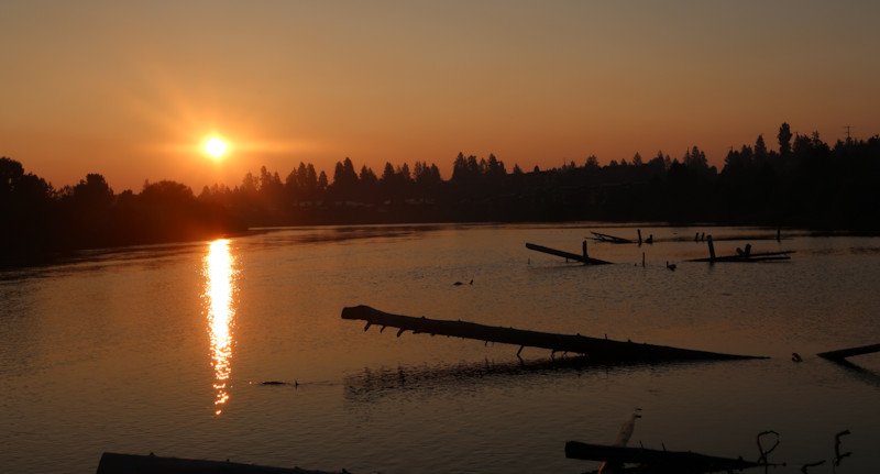 A smoky, hazy sunrise from the Deschutes River boardwalk in Bend