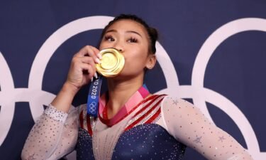 Suni Lee poses with her gold medal