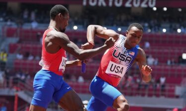 Fred Kerley and Ronnie Baker pass the baton while running on the track