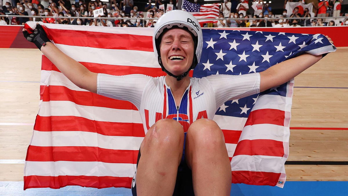 Jennifer Valente of Team United States celebrates winning the gold medal while holding the flag of her country during the Women's Omnium points race