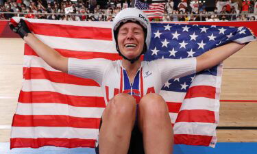 Jennifer Valente of Team United States celebrates winning the gold medal while holding the flag of her country during the Women's Omnium points race