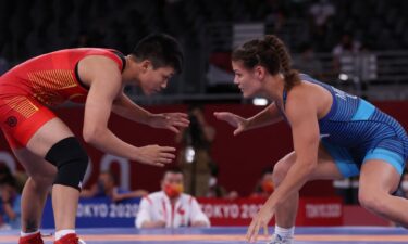 Team USA's Kayla Miracle in blue wrestles China's Long Jia in Tokyo