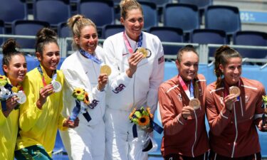 Women's beach volleyball's six medal winners smile and show their prizes