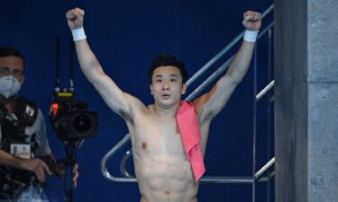 China's Cao Yuan celebrates winning the gold medal in the men's 10m platform diving event at the Tokyo Olympics.