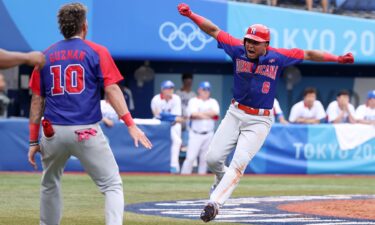 Infielder Erick Mejia of the Dominican Republic celebrates scoring a run with his team mate Jeison Guzman after a two-run double by Juan Francisco during the bronze medal game between Dominican Republic and South Korea.