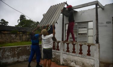 Men placed a corrugated metal sheet on the roof of a house in Batabano