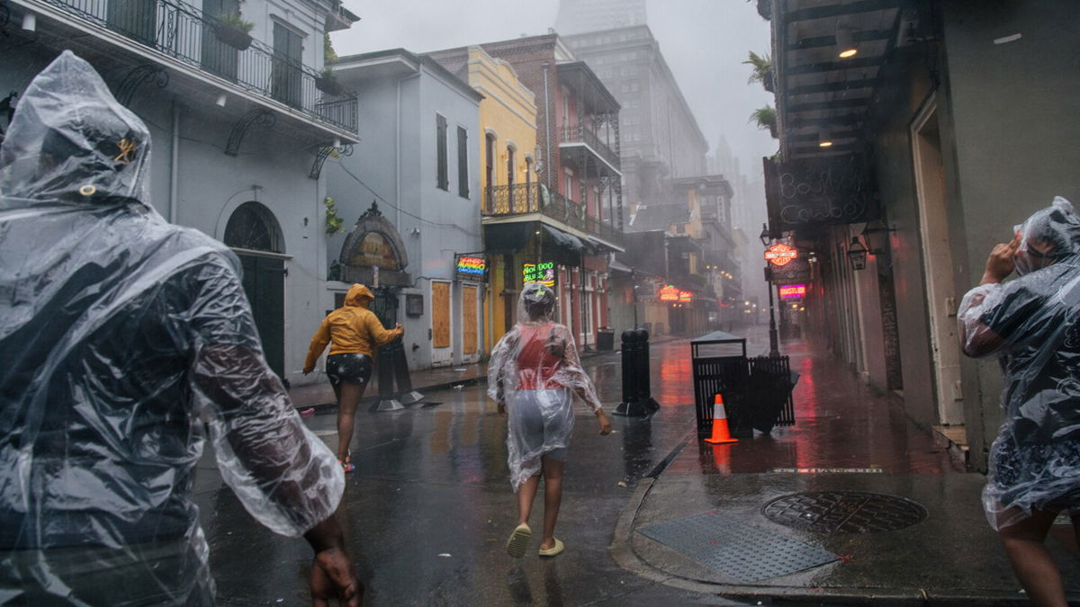 <i>Brandon Bell/Getty Images</i><br/>A group of people walk through the French District during Hurricane Ida on August 29