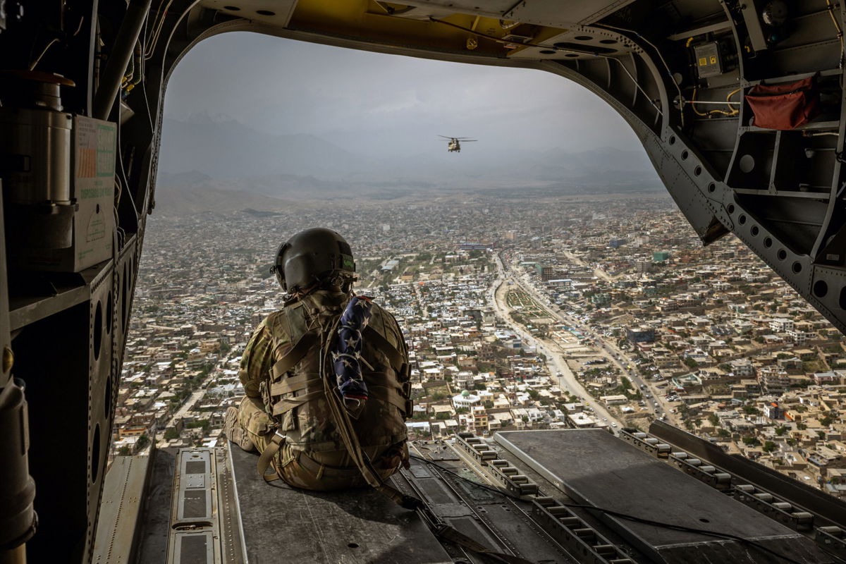 <i>Jim Huylebroek/The New York Times/Redux</i><br/>An American soldier on a CH-47 Chinook helicopter flies over Kabul
