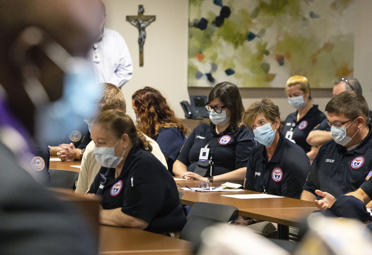 <i>Ted Jackson/AP</i><br/>Father Don Ajoko prays Monday for blessings for nearly three dozen health care workers from around the country who arrived to help at Our Lady of the Lake Regional Medical Center in Baton Rouge