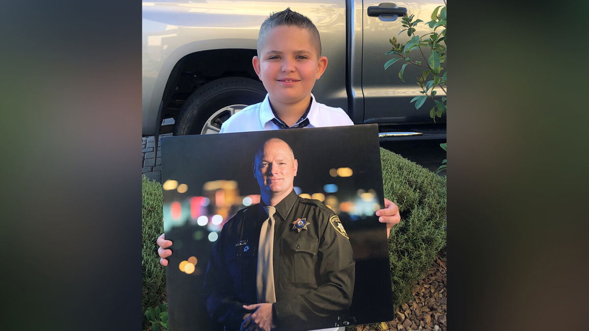 <i>LVMPD</i><br/>Noah holds a photo of his late father