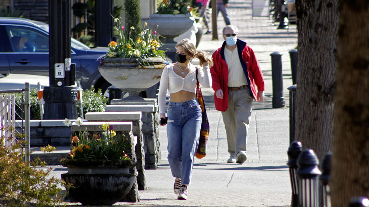 <i>Gillian Flaccus/AP</i><br/>Oregon will soon require people to wear masks outdoors in public settings where physical distancing isn't possible. People wearing masks here walk in downtown Lake Oswego