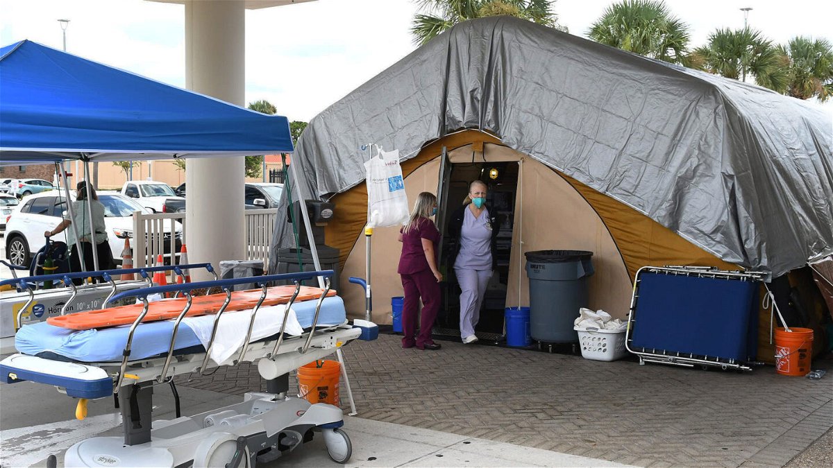 <i>Paul Hennessy/SOPA Images/LightRocket via Getty Images</i><br/>Nurses work at a treatment tent outside the emergency department at Holmes Regional Medical Center in Melbourne