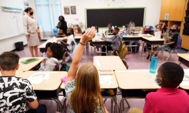 A student raises their hand in a classroom at Tussahaw Elementary School in McDonough