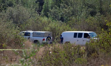 Forensic technicians work at the scene where two young American children were found dead in Rosarito