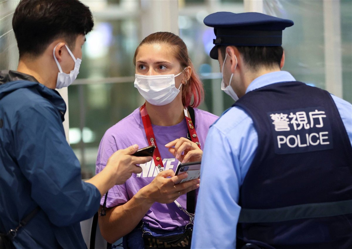 Belarusian athlete Kristina Timanovskaya talks with police at Haneda international airport in Tokyo on August 1.
