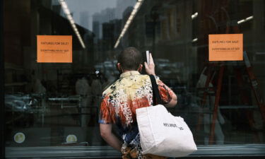 A person pauses in front of a closed Kmart store at Astor Place in New York's East Village on July 13