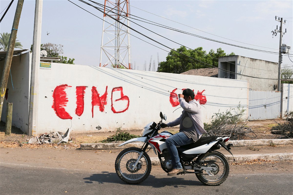 <i>Alan Ortega/Reuters</i><br/>A motorist passes by a wall with a graffiti of the Jalisco New Generation Cartel (CJNG) in Michoacan state