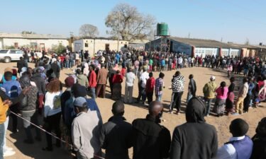 People wait in a long queue at a polling station in Lusaka