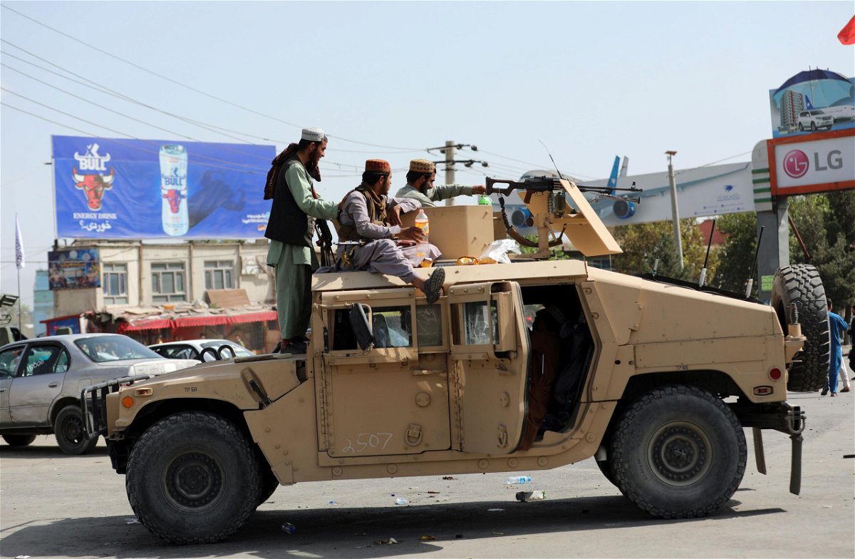 <i>Rahmat Gul/AP</i><br/>Taliban fighters drive an American Humvee in Kabul on Monday