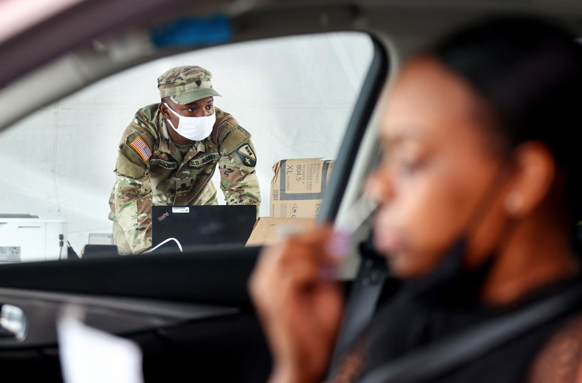 <i>Mario Tama/Getty Images</i><br/>A driver administers a self-collected nasal swab at a Covid-19 drive-through testing site operated by the National Guard on August 11