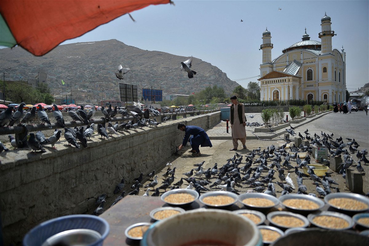 <i>Hoshang Hashimi/AFP/Getty Images</i><br/>Life appears to be creeping back to normal in Kabul on Wednesday. This image shows young Afghans feeding pigeons near the Shah-Do-Shamshira Mosque in Kabul on August 18.