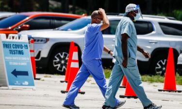 Health care workers leave following a shift at a drive-thru Covid-19 testing site at Tropical Park in Miami on