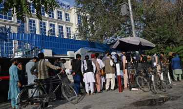People in Afghanistan wait in line to withdraw money from an ATM in Kabul on August 21.