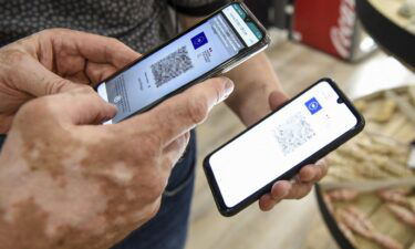 A person uses a pass verification application on a smartphone to check a health pass displayed on a smartphone in Amneville
