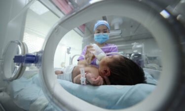 A medical staff member here feeds a baby at a hospital in Danzhai