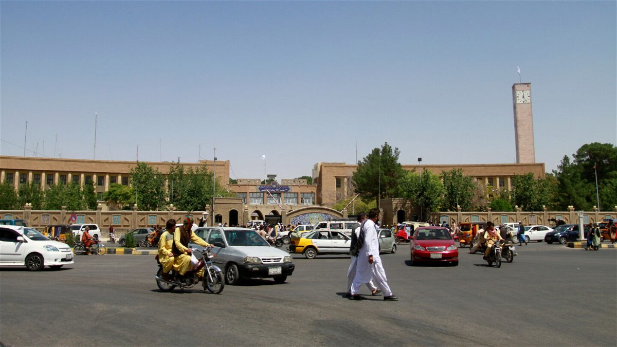 <i>Hamed Sarfarazi/AP</i><br/>Pedestrians and motorists travel near the Herat provincial official office on Aug. 14 after the province was taken by the Taliban several days before.