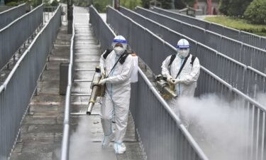China's economy stalled this month due to the Delta variant and ongoing shipping crisis. Workers spray disinfectant to halt the spread of Covid-19 on August 26